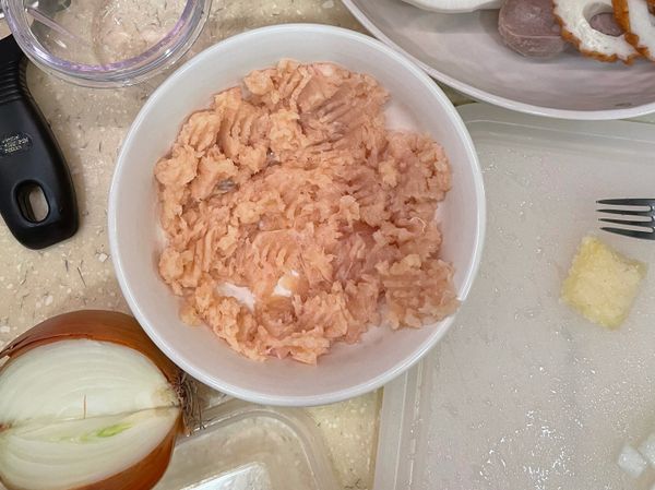 用料理機或菜刀把雞肉剁碎，鋪在碗內，灑上鹽巴跟白胡椒調味