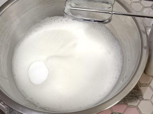 打至小泡泡，加入剩下的糖，繼續打發