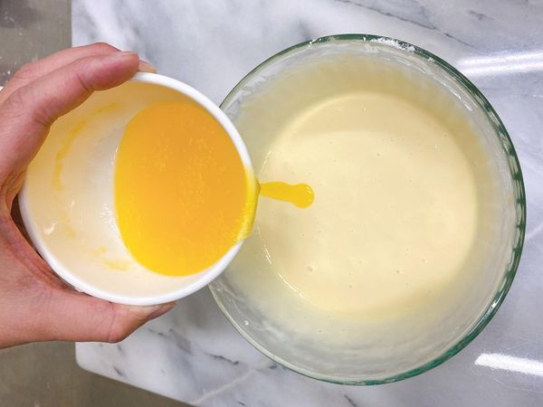 加入溶化成液狀的奶油，攪拌攪拌，靜置5分鐘。

如果麵糊中還有未散開的麵粉顆粒，不必太認真攪散它，在靜置的過程中粉粒會自然溶解開來。

靜置後再攪兩三下麵糊就會非常滑順均勻。