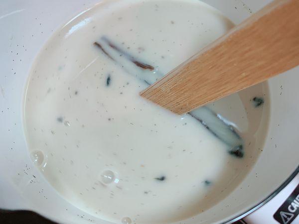 牛奶和糖加入小鍋裡，取出半根香草莢，刮出裡面的香草籽，一起和香草莢放入鍋中。
小火加熱至糖融化即可。