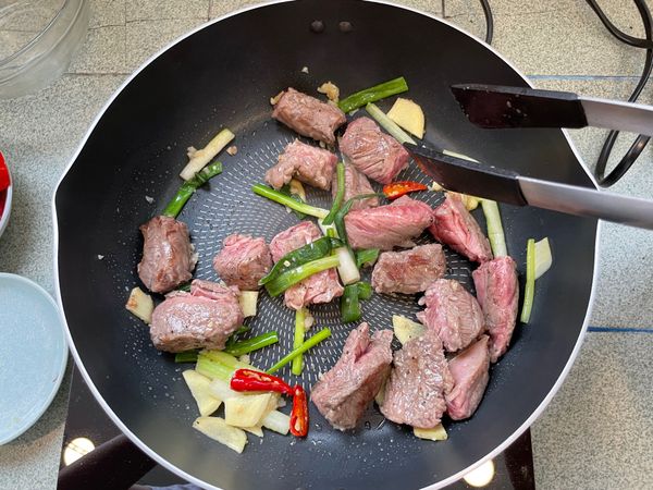 接著將蔥段、薑片、辣椒、蒜泥加入拌炒出香氣