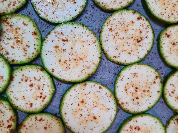 櫛瓜洗凈切片（不要太厚），每一片整齊放入烤盤，接著淋上橄欖油，灑上孖然粉、紅椒粉，烤箱180゜15min