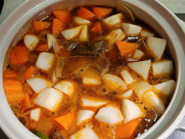 加入米酒／冰糖／白胡椒粉拌炒一下，接著加入紅白蘿蔔塊，最後上面放上花椒粒，將水加至蓋到蘿蔔塊，大火煮滾後，蓋上鍋蓋以小火燉一個小時。
於最後5分鐘的時候，開蓋加鹽巴調味道。