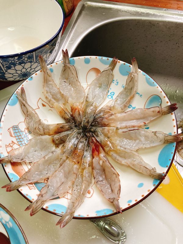 2.先去掉頭部的胃囊 再把蝦腸用牙籤去除  沿著蝦子的背部 一路開到蝦尾 (可以用剪刀 也可以用刀子)
(圖2)