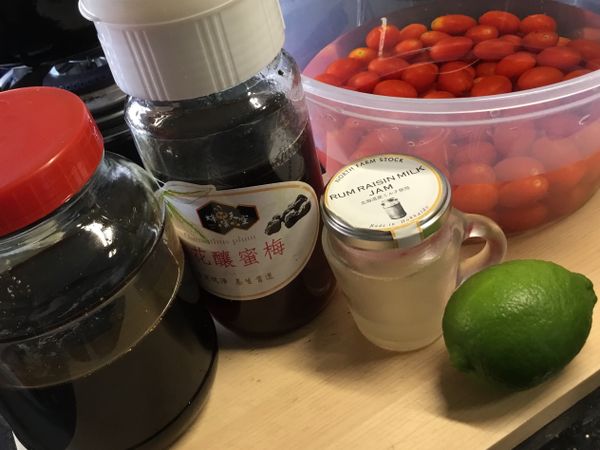 將準備好的小蕃茄洗淨，用小刀輕輕在每個蕃茄的表面上畫上三、四刀的刀痕，準備鍋子將水煮沸，將處理好的小蕃茄全部倒入鍋中，煮沸的狀況下煮約30秒就撈起放入在ㄧ旁備好的冰開水中，接著就把每個小蕃茄的表皮去掉。