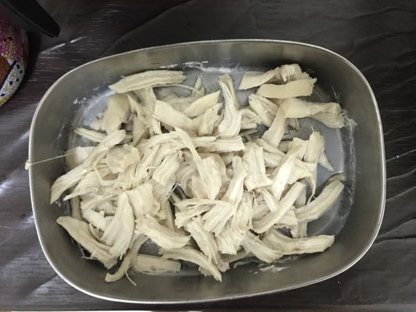 蒸熟的雞胸肉，倒掉多餘的水，用手撕成適口大小的肉絲，也可以使用兩隻叉子，撕雞胸肉。