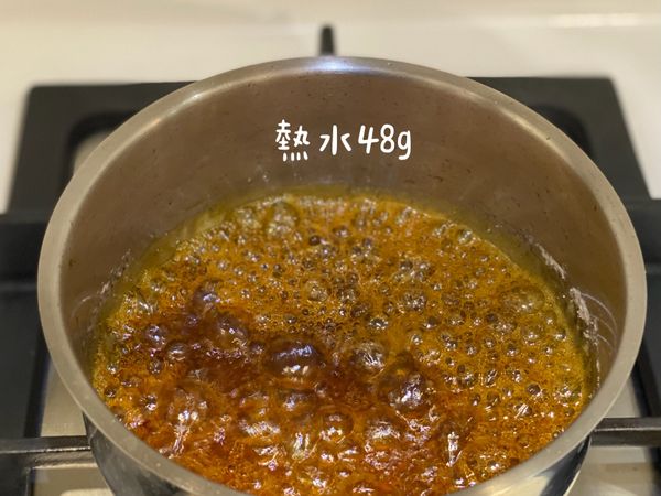 將熱水分次倒入，此時熱氣會衝上來要非常小心，分次倒入的好處是可以依照當時情況判斷焦糖的濃度，太稠、太稀都會影響到布丁的成果，最好的程度為焦糖倒入布丁杯時會緩慢移動