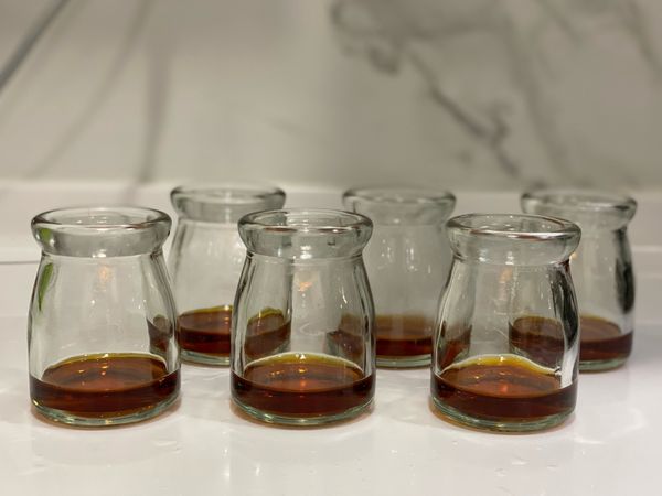 趁焦糖未凝固之前分裝至布丁杯，待微涼後可放置冰箱冷藏