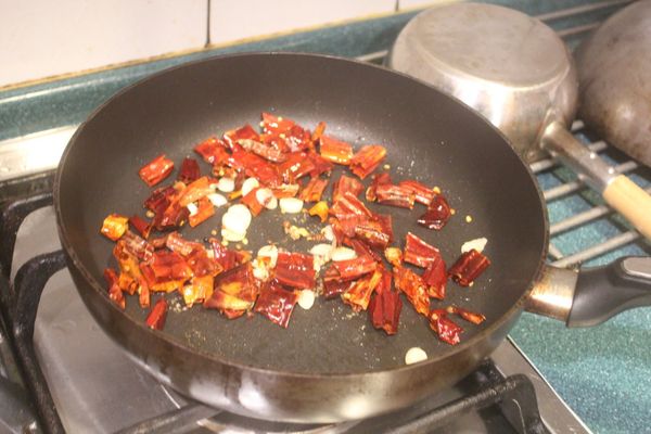 加入乾辣椒和花椒粒及1-2大匙炸油，炒香。