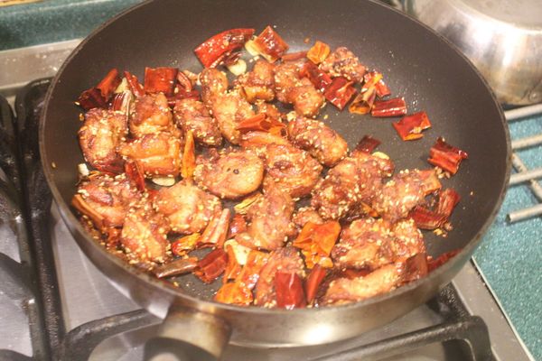 將雞肉回鍋，加入胡椒粉、少許鹽和糖炒一下。