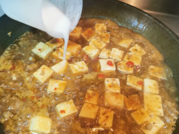 大約煨煮4-5分鐘，慢慢淋上太白粉水勾芡
慢慢推豆腐 不要翻炒 會破
一分鐘左右看看濃稠度
若不夠可以二度勾芡
（記得不要看他沒馬上變濃稠就繼續加，太白粉水會慢慢變濃稠）