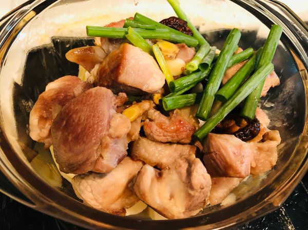 在筍塊上方倒入剛剛拌炒的豬肉、香料和蔥綠