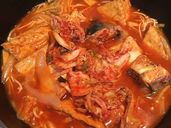 金針菇出水後，湯汁就變多了。再加入鯖魚、1/2碗的泡菜，再次煮滾後，調整味道，最後再加入少許烏醋即可。食用前灑上蔥綠。