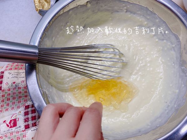 趁奶油乳酪糊還熱的時候加入軟化的吉利丁片，攪拌至吉利丁片完全融化為止。