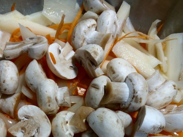 待馬鈴薯炒至八分熟時，加入蘑菇一起炒。