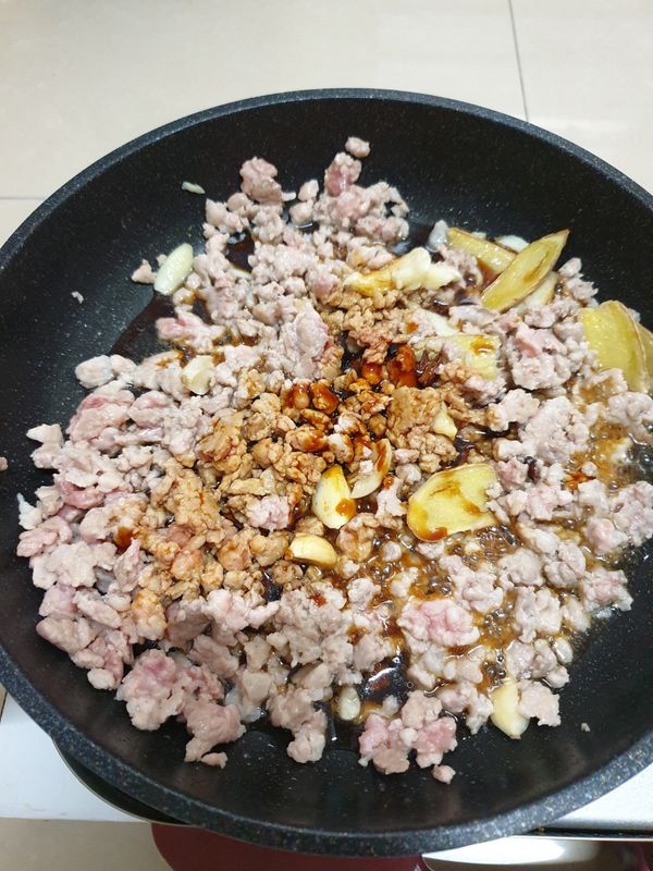 豬肉轉白後嗆入米酒，加入醬油、醬油膏、白胡椒粉