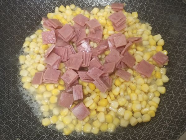 倒入玉米和火腿，加鹽，翻炒拌勻至滾。
再倒入剛才煮好的蛋，拌勻就可以囉！