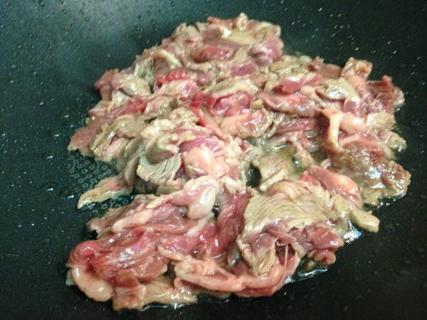 一大匙油熱鍋，將牛肉片大火炒到半熟後盛起。