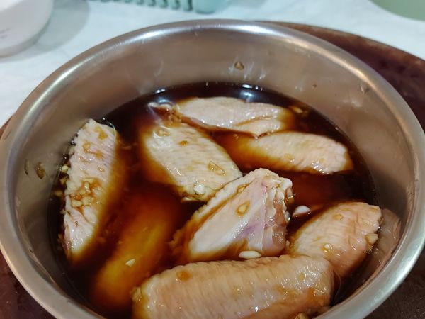 將雞翅放進去後加水至蓋住雞翅（大概是玻璃碗的1／3的量），輕輕的抓醃一下後，放進冰箱30分鐘以上。