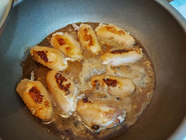 在熱鍋中加入適量的油，接著將雞翅兩面都煎到有一點焦焦的再把醬汁倒入（開中小火）。