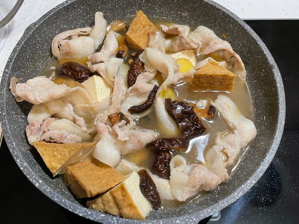 下香菇炒香，加入香菇水、鹽滷油豆腐滷汁及一些水、適量鹽巴及白胡椒，蓋上鍋蓋悶煮約五分鐘