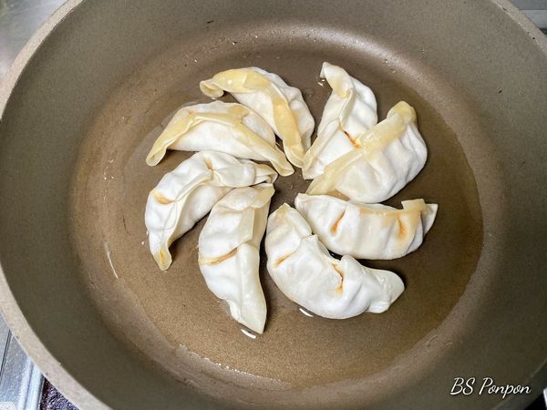 平底鍋倒入適量的沙拉油，把水餃排放在鍋內~小火先煎2~3分鐘，煎的過程記得移動水餃，確認沒有黏鍋的現象