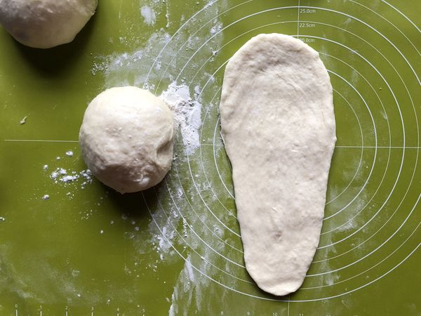 將麵糰擀成長度約25cm上寬下窄的薄麵皮。