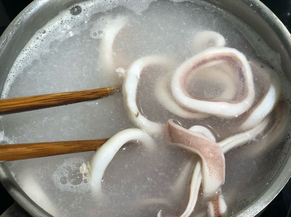 水滾之後把魷魚圈放進鍋子裡，汆燙到魷魚圈變白，有點彈性即可撈出。