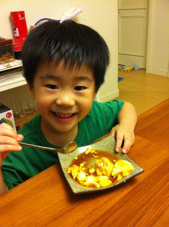 阿凱吃得笑嘻嘻，一整顆三兩下吃光光，豆漿布丁成功！