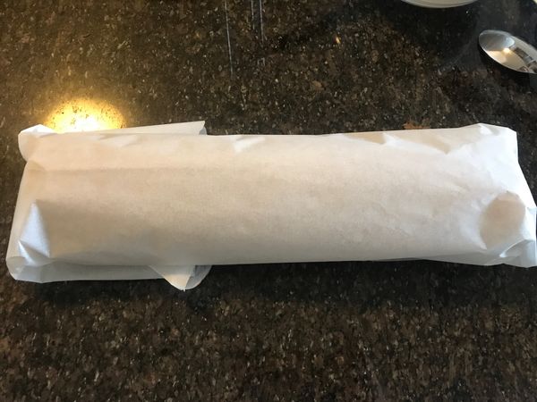 由自己身體這一側抓住烤紙緊密往外捲,一邊捲一邊往前推(可以網路查影片作法),烤紙將整條蛋糕捲起
用另一張長一點的烤盤紙包好,冷藏至少4-5小時定形,食用前頭尾不整齊切除即可