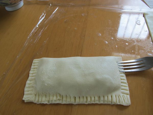 將邊緣以叉子壓緊, 在頂端處劃上三刀.