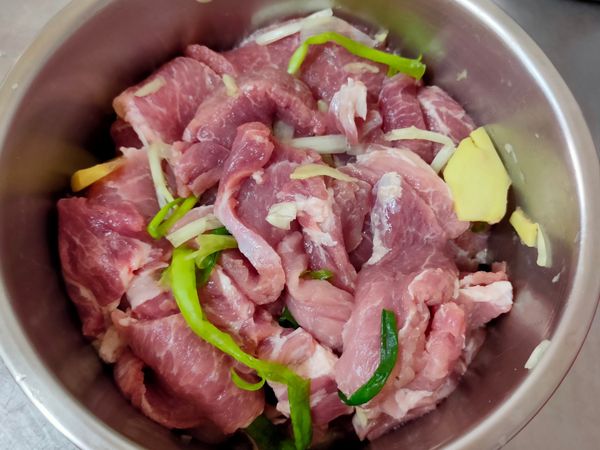肉放入鍋中，和蔥薑蒜抓醃一下。