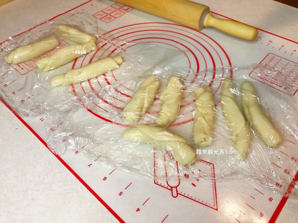 把油皮分成每個22克的小麵團，油酥分成每個15克的小塊。把油酥包進油皮裡面後，桿長後捲起，放入保鮮膜鬆弛15分鐘；再桿一次，再捲起放入保鮮膜鬆弛15分鐘。