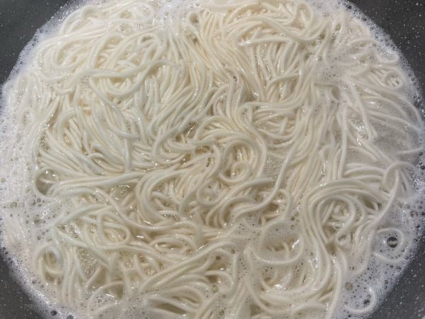 滾水煮麵，將煮好的麵放入碗中，淋上適量的蔥油拌勻，放上炸酥的蔥段再撒些新鮮的蔥花即可。