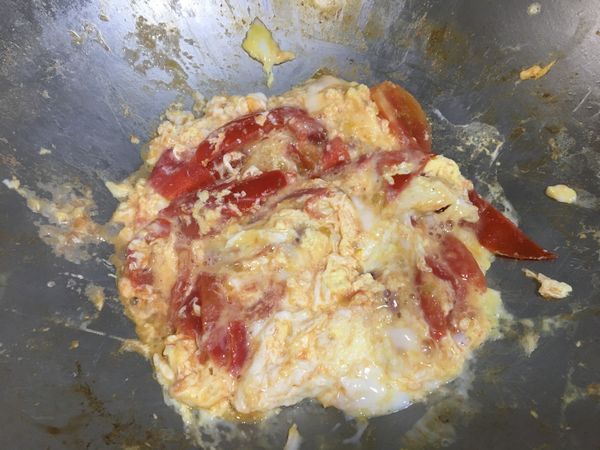 番茄翻動一下後，蛋液下鍋。下鍋後不要翻動，維持原樣煮一下。

這時候的火候請自行判斷，若蛋液很快就熟了，代表火可能太大或水太少。如果蛋液一直都還沒凝固，那可能是水太多了。

蛋液開始凝固，且水開始少了，就可以翻動，讓上部的蛋液煮熟。