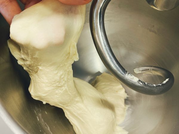 加入鹽慢速攪打一分鐘再加酵母慢速打1分鐘改中速打7分鐘，呈擴張光滑狀態