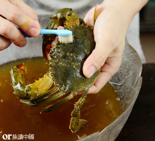 將螃蟹放入冷凍庫約15-20分鐘使螃蟹凍暈，然後剪開縛繩，用牙刷在細流清水下刷洗螃蟹的頭胸軀幹、關節、螯足等處。