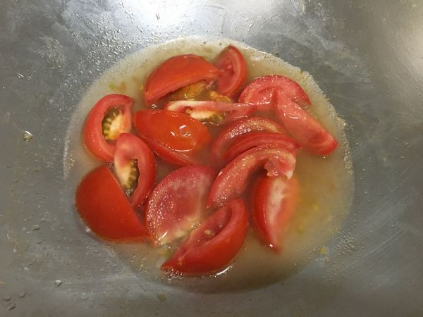 下油熱鍋後，番茄下鍋翻炒，加水，再翻炒，開中小火不翻動繼續煮。