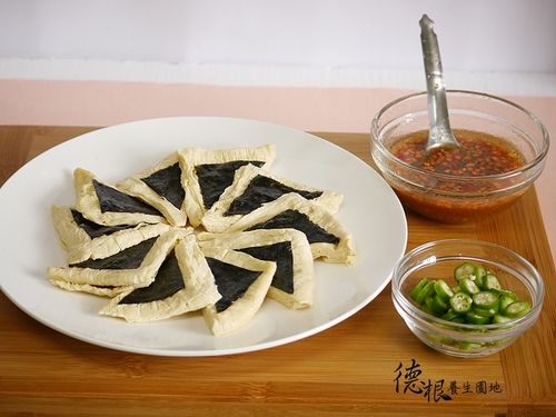 材料洗淨，豆包對角切成2片〈三角型〉，擺入盤中，壽司海苔，剪約4公分正方形再對角剪成2片三角形，每片豆包貼1片海苔