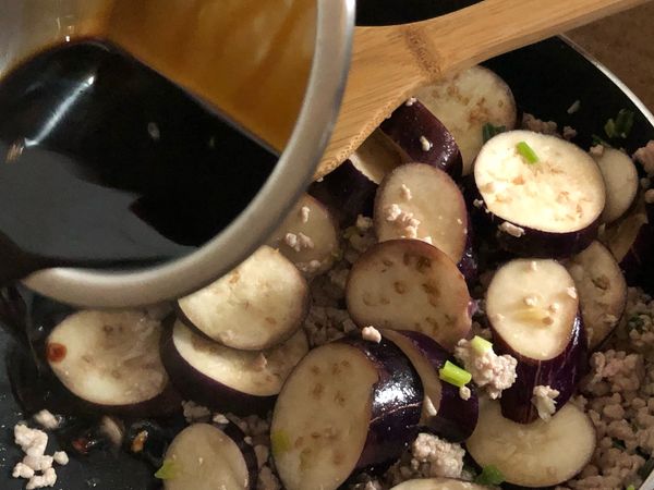 沿著鍋邊加入醬油，將所有食材拌炒均勻入味。