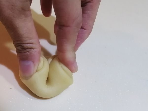 皮平放, 收口朝上，用一根手指往中間壓扁, 此時圓的那一面會往中間移動, 然後再用掌心壓扁。