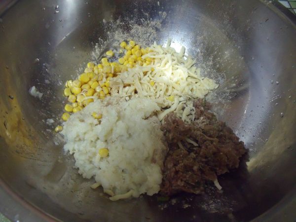 牛絞肉加入醃料拌勻再加入洋蔥跟蔥花拌勻,再倒入盆中跟玉米粒跟搗碎的馬鈴薯泥,起司絲攪拌成糰。