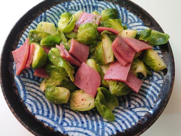 奶油融化後，抱子甘藍先入鍋悶煮1-2 min，加水悶煮，最後再加入火腿燜煮。起鍋前灑點鹽和黑胡椒。