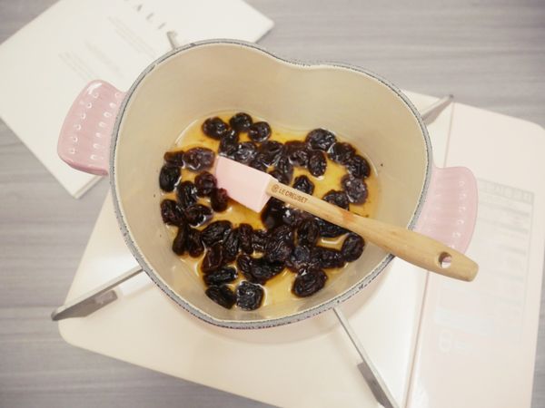 先來製作蘭姆酒葡萄，將葡萄乾、水及砂糖煮至滾後關火加入蘭姆酒拌勻。