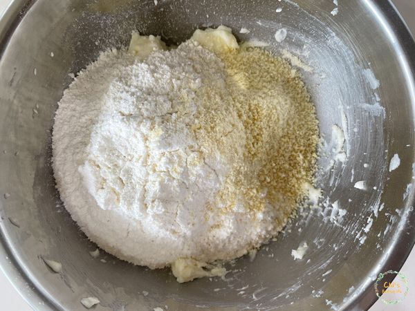 加入過篩後的低筋麵粉及杏仁粉，用橡皮刮刀稍微拌勻