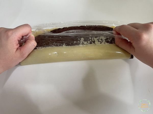 將可可麵糰鋪在原味麵糰上，將四邊用刮板切掉不平整的地方這樣捲好後比較美觀，我是沒有切啦＼(º □ º l|l)/
捲好後稍微滾一下放冷凍１小時，或是冷藏３小時