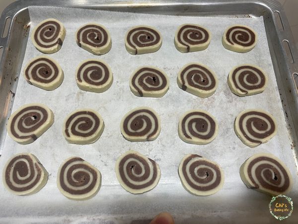 確定麵糰已經冰硬後，烤箱預熱上火１７０度 下火１３０度
若上下火無法分開設定，烤溫請選擇１５０度
將麵糰切成厚度１公分，切好後用手稍微整圓一點
預熱好後將烤盤放入中層烤２５分鐘，改放置上層烤５分鐘讓表面上色