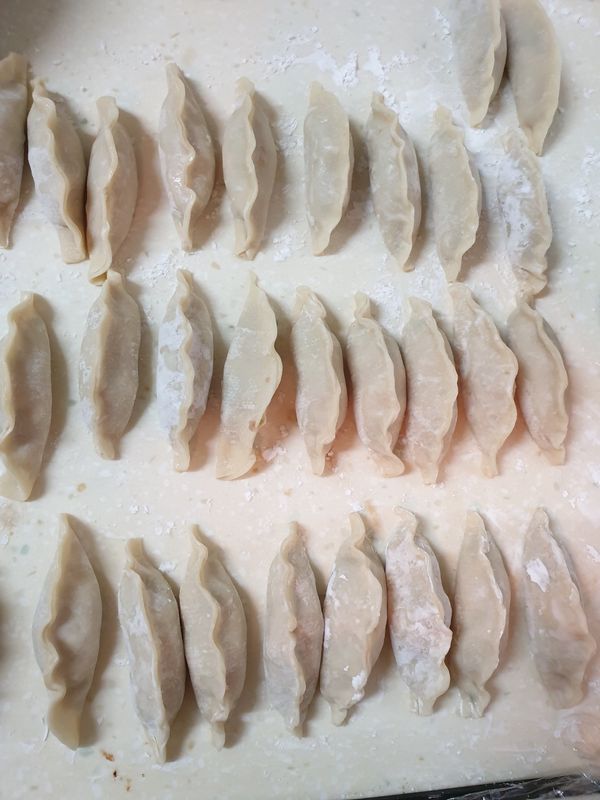 將餡料包入餃皮中；手腳要快否則皮會濕軟