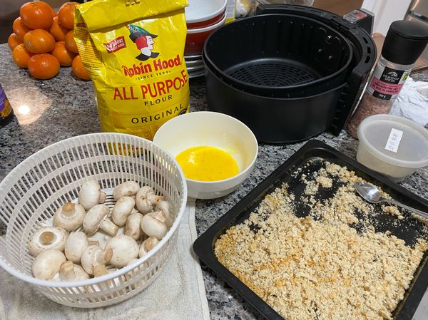 依次把蘑菇滾上麵粉、蛋漿、麵包糠。