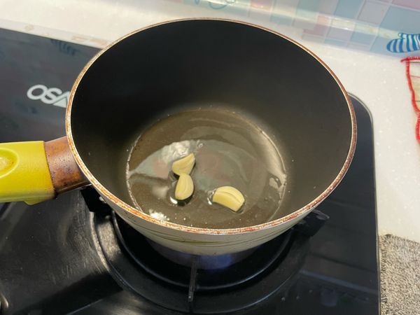 放約兩個十元硬幣大小的油熱鍋
油熱後放入蒜頭片